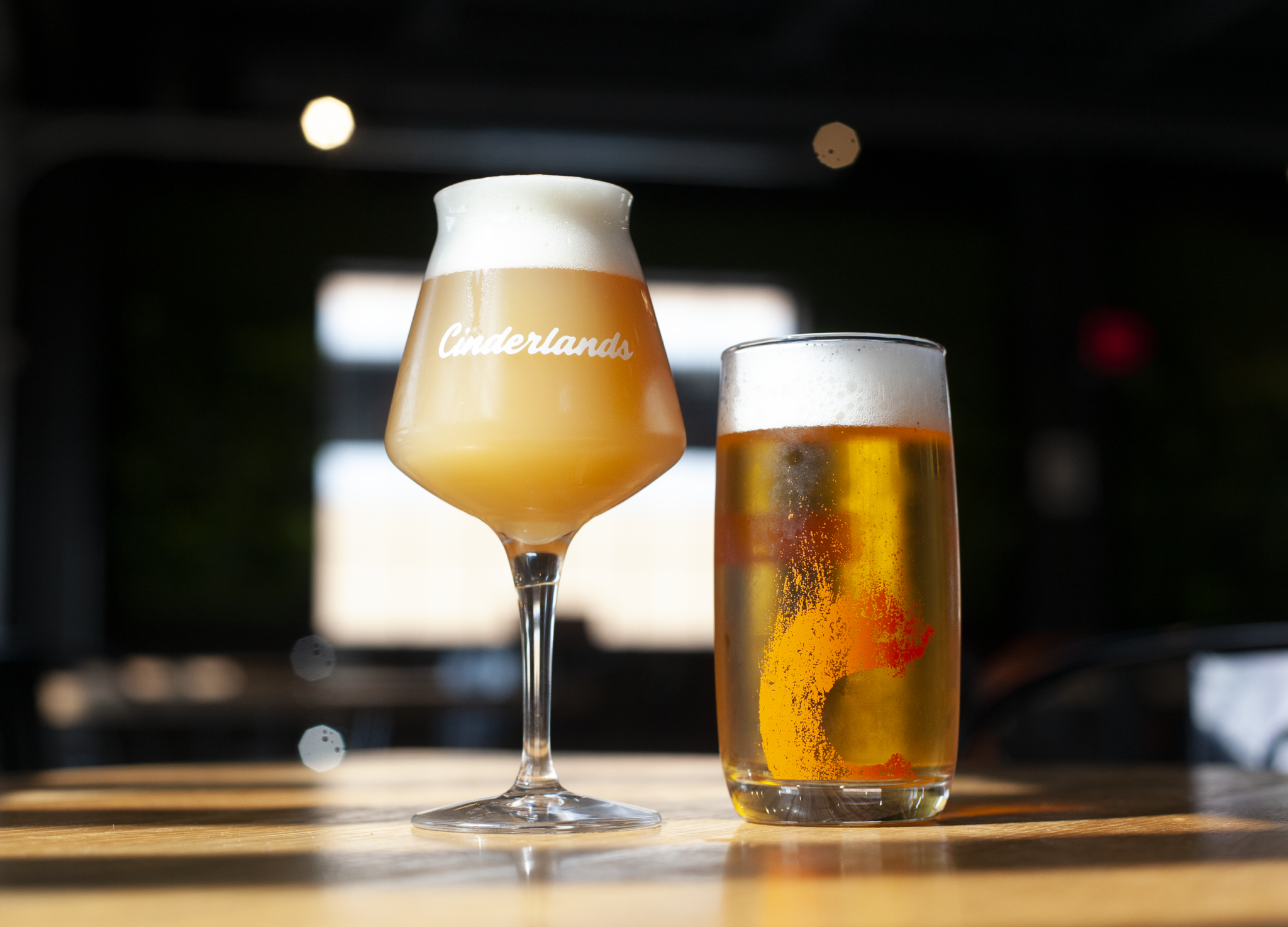 A Cinderlands stemmed glass and a pint of lager on the bar