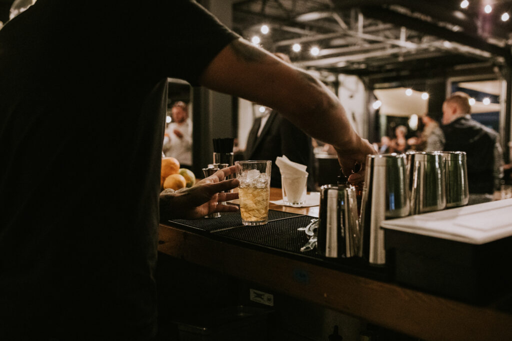 Bartender pouring a cocktail at a Cinderlands Warehouse event
