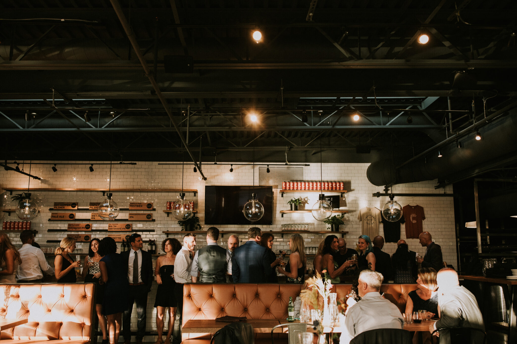 Guests in party clothes mingling at the bar inside the Cinderlands Warehouse in Pittsburgh's Strip District