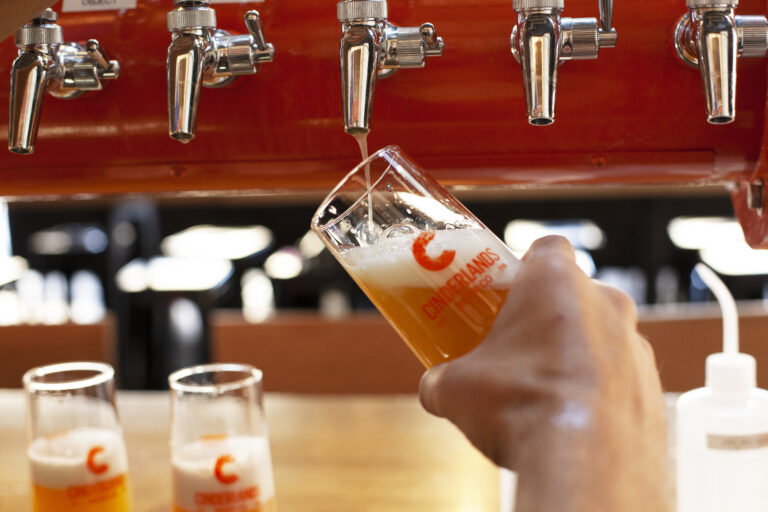 Pouring a hazy beer from the draft taps at the Cinderlands Warehouse