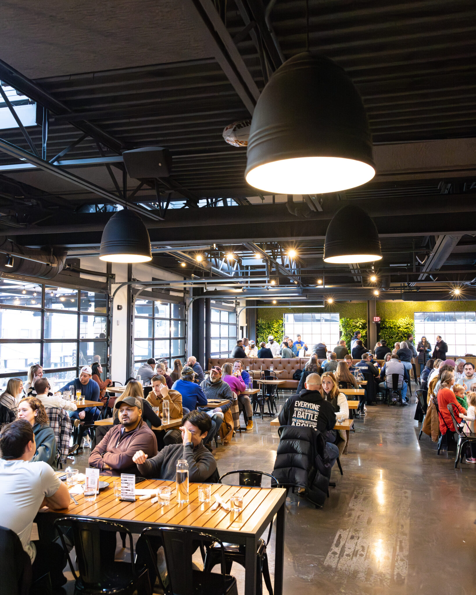 The Cinderlands Warehouse dining room full of guests under the big pendant lights