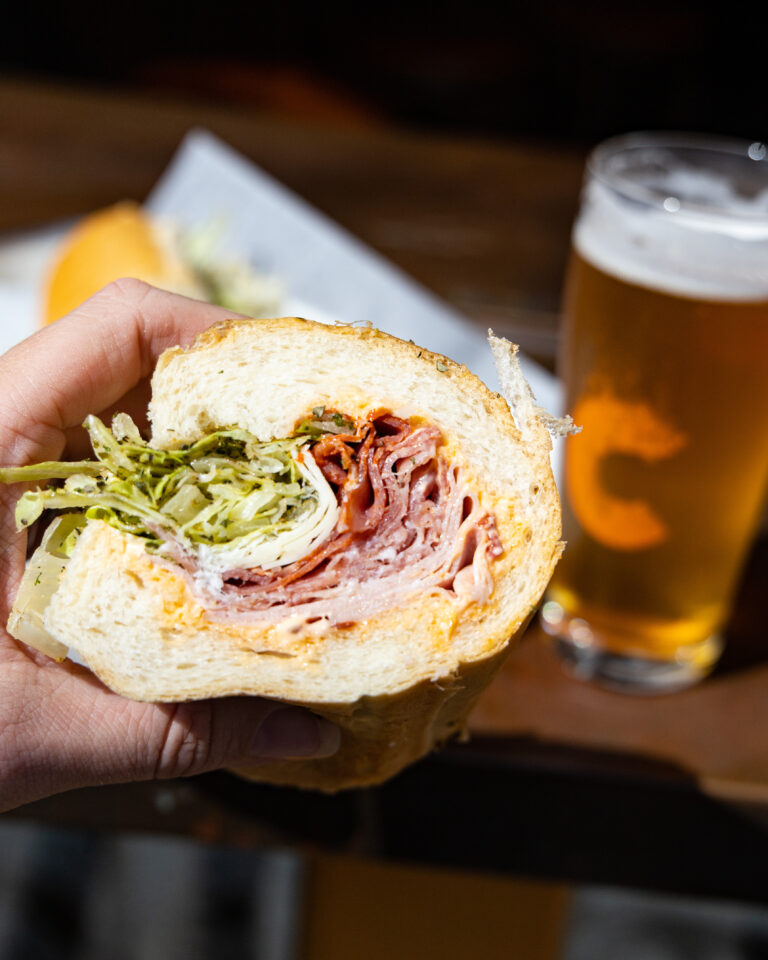 A stacked hoagie in hand with a Cinderlands beer at Long Story Short