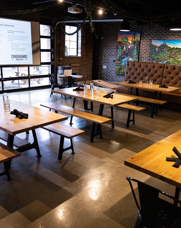 The First Floor of the Cinderlands Warehouse set for a business meeting, projector screen and tables with notepads